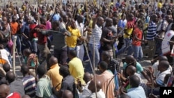 Striking mine workers armed with machetes, sticks, and spears march to a smelter plant at the Lonmin Platinum Mine near Rustenburg to hand over a memorandum to mine management and to ensure that workers had not reported for duty, Sept, 12, 2012.