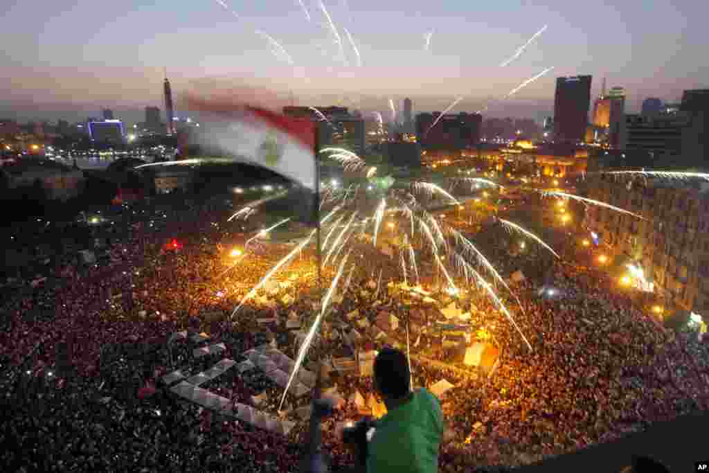 2014年6月30日，埃及人聚集在开罗解放广场，举行反对总统穆尔西的示威。一名抗议者挥舞旗帜。