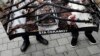 Members of the Independent Journalists' Association hold a poster shows a journalist Milan Jovanovic in his burned house that reads: "What are we waiting for?" during a protest in Belgrade, Serbia, Dec. 12, 2019.