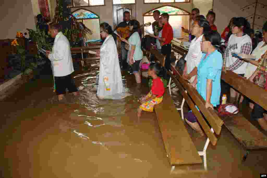 Christians attend the mass service at a flooded church in Bandung, in western Java island, Indonesia, Dec. 25, 2014.