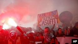 Un manifestant tient une fusée éclairante lors d'une manifestation à Paris, en France, le mercredi 15 mars 2023. 