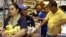 People hold their groceries as they line up to pay the cashier at a supermarket in Caracas, Veneuela, Aug. 21, 2014.