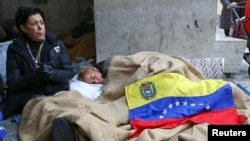 Lilian Tintori, wife of jailed Venezuelan opposition leader Leopoldo Lopez, sleeps on the pavement next to Leopoldo's mother, Antonieta Mendoza, near St. Peter's Square in Rome, Dec. 6, 2016.