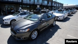 FILE - A fleet of Uber's Ford Fusion self-driving cars are shown during a demonstration of self-driving automotive technology in Pittsburgh, Pennsylvania, Sept. 13, 2016.