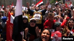 Anti-Morsi protesters carrying posters of army chief Abdel Fattah el-Sissi chant slogans at a mass rally to support the army, in Cairo's Tahrir Square, July 26, 2013.