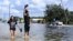 FILE - Neryliz Rivera, left, and Luis Arroyo walk through a flooded city street in the aftermath of Hurricane Helene, Sept. 27, 2024, in Crystal River, Fla. 