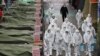 Para petugas mengenakan pakaian khusus saat akan menyemprotkan disinfektan di sebuah pasar di kota tenggara Daegu sebagai tindakan pencegahan saaat merebaknya wabah korona di Korea Selatan, 23 Februari 2020. 