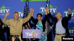 Virginia Democratic gubernatorial nominee and former governor Terry McAuliffe stands on stage with Democratic Virginia Lt. Gov. candidate Hala Ayala and Virginia Attorney General Mark Herring at Caboose Commons in Fairfax, Va., Nov. 1, 2021.