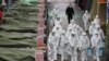 Workers wearing protective gear spray disinfectant at a market in the southeastern city of Daegu, South Korea, as a preventive measure after the COVID-19 coronavirus outbreak. South Korea reported two additional deaths from coronavirus and 123 more cases.