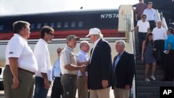 Le candidat républicain Donald Trump, suivi de son colistier Mike Pence, est accueilli par le procureur général de la Louisiane Jeff Landry à l'aéroport de Baton Rouge, 19 août 2016.