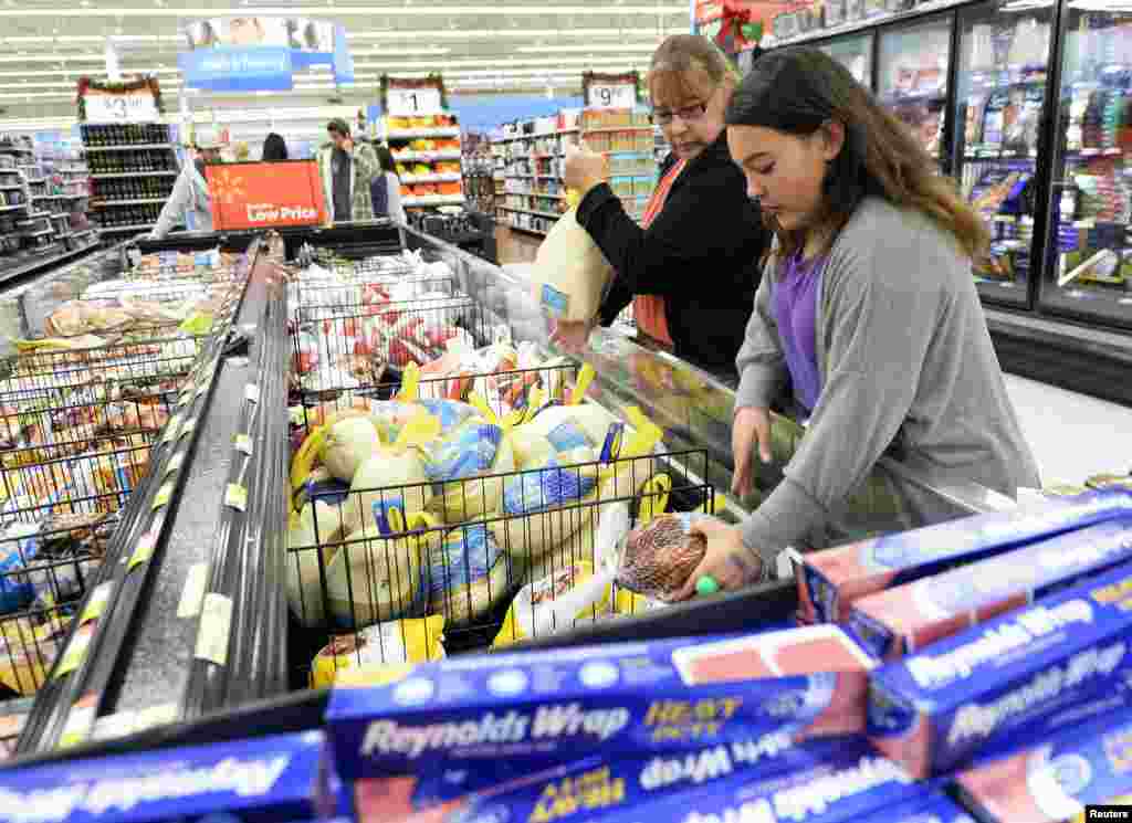Tina Corpus and her daughter, Christina, shop for turkey at a Walmart store in the Porter Ranch section of Los Angeles, California, Nov. 26, 2013. 