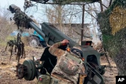 FILE - In this photo taken from a video and released Nov. 29, 2024, a Russian serviceman aims a D-30 howitzer toward Ukrainian positions in the Kursk region, Russia. (Russian Defense Ministry Press Service via AP)