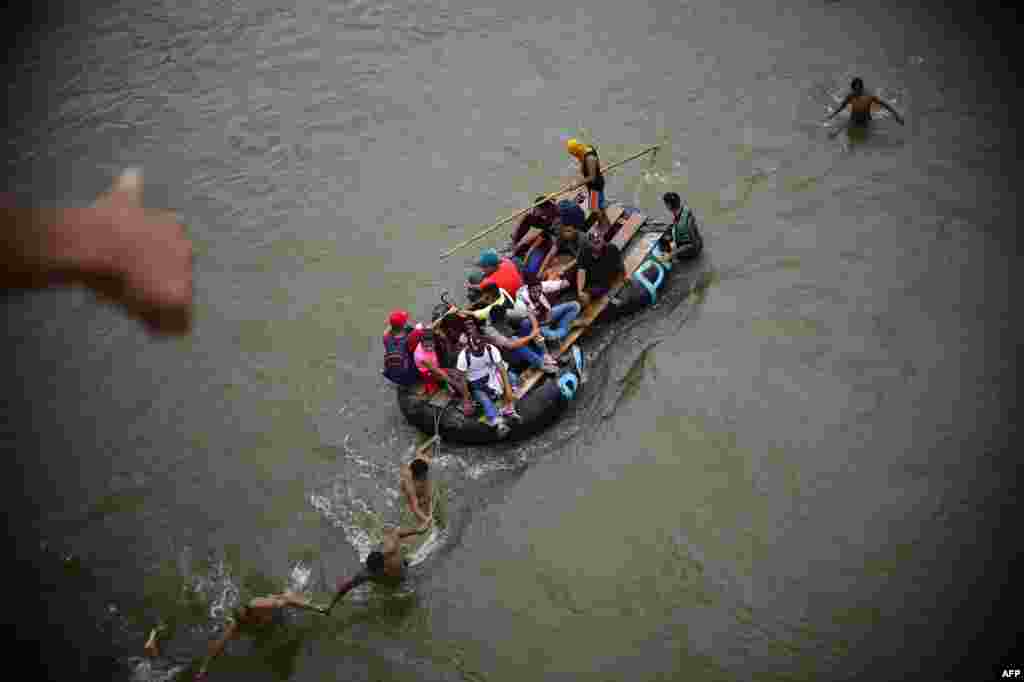 Honduran migrants are seen on a makeshift raft in the Suchiate River from the Guatemala-Mexico international border bridge, in Ciudad Hidalgo, Chiapas state, Mexico, Oct. 20, 2018.
