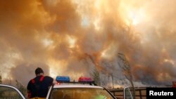 Seorang petugas pemadam kebakaran turun dari truknya ketika api unggun mendekati kota Labertouche, 90 km sebelah timur Melbourne, 7 Februari 2009. (Foto: Reuters)