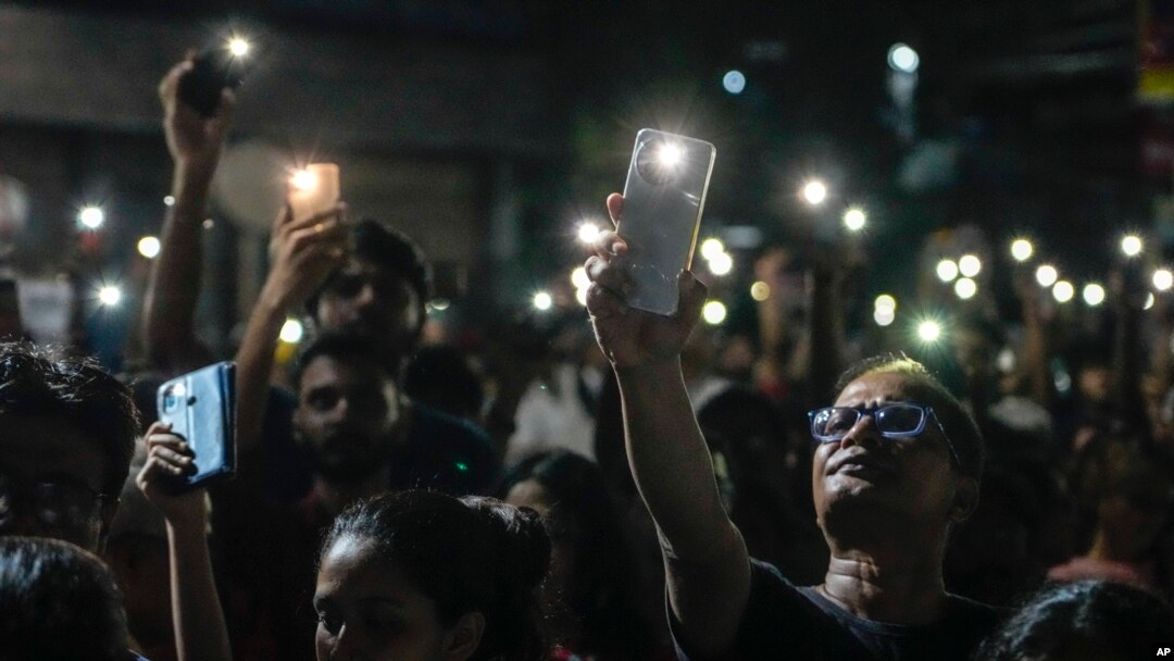 Orang-orang menyalakan senter ponsel mereka saat mengikuti unjuk rasa tengah malam untuk menuntut keadilan bagi Dokter yang dibunuh di Kolkata, India, Minggu, 8 September 2024.