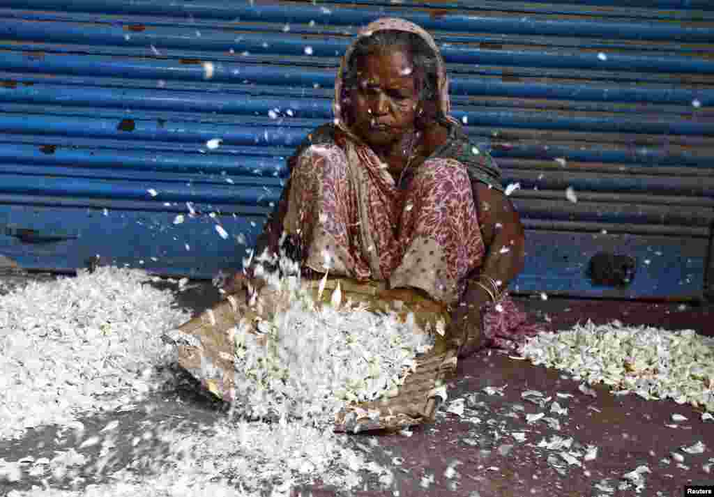 A laborer removes the skin of garlic at a wholesale market in Kolkata, India.