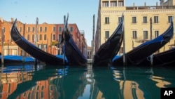 Gondola-gondola tampak bersandar di Grand Canal, Venesia saat pemerintah Italia meminta warga untuk tinggal di rumah karena wabah virus corona, Senin, 6 April 2020. (Foto: AP)