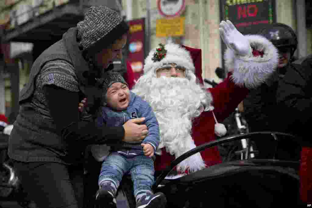 Seorang bayi menangis ketakutan ketika bertemu &quot;Santa Claus&quot; yang menaiki Sespan di kota tua Yerusalem.