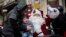 A man dressed as Santa Claus visits and gives Christmas presents at a family's home on the Christmas Eve in Espoo, Finland.