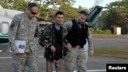 U.S. military servicemen assist freed Australian national Warren Richard Rodwell after he gets off a helicopter inside a military camp in Zamboanga City, southern Philippines, March 23, 2013, in this picture provided by the Western Mindanao Command of the