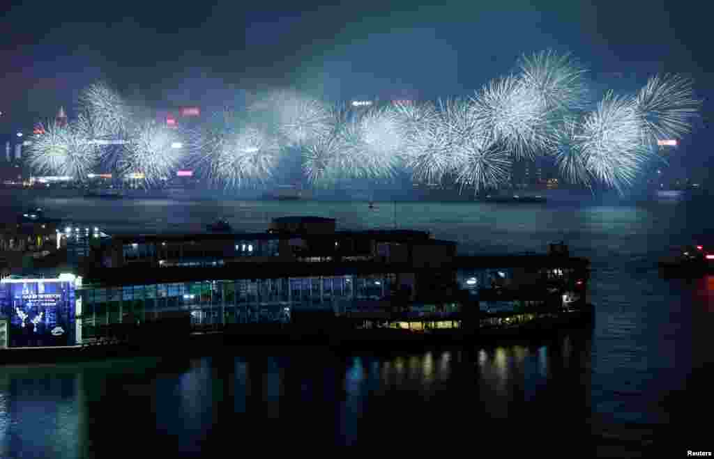 Fireworks explode over a cloudy Victoria Harbour during Lunar New Year celebrations in Hong Kong, China.