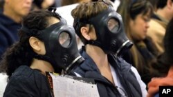 Des manifestants portent des masques à gaz pour protester contre une fuite de gaz à l'installation de stockage Aliso Canyon en Californie.