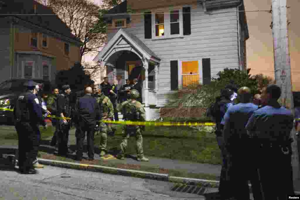 Law enforcement officials are seen in front of 67 Franklin St after the capture of Dzhokhar Tsarnaev, the surviving suspect in the Boston Marathon bombings, in Watertown, April 19, 2013. 