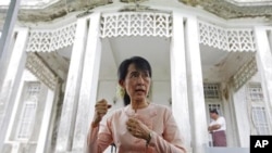 Pro-democracy leader Aung San Suu Kyi talks to reporters at her home in Yangon, July 11, 2011