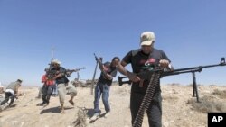 Wapiganaji waasi nchini Libya wakifyatuliana risasi na majeshi yanayomtii Moammar Gadhafi, nje ya mji wa Kikla, kiasi cha kilomita 40 kutoka mji wa Gheryene nchini Libya