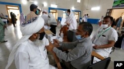 A teacher receives Sinovac coronavirus vaccine in Lahore, Pakistan, May 28, 2021. The WHO said data submitted by Sinovac indicated that two doses of the vaccine prevented symptoms from developing in just over half of those who received vaccinations.