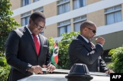 Lazarus Chakwera (L), the president for Malawi’s main opposition Party, the Malawi Congress Party, and his running mate, Saulos Klaus Chilima (R), gesture while they leave the Mount Soche Hotel in Blantyre, May 6, 2020.
