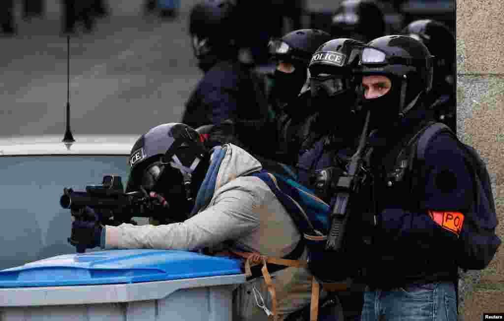 A French police officer aims at protesters with his LBD40 rubber bullets during a demonstration of the &quot;yellow vests&quot; movement in Nantes, Jan. 26, 2019.