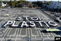 Aktivis Greenpeace mengacungkan huruf-huruf raksasa yang membentuk kata 'Stop Plastik' untuk memprotes sampah plastik di Heroes Square, Budapest, 30 September 2018.
