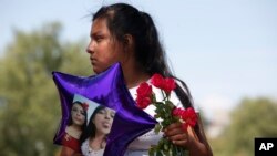 Seorang kerabat Angelica Ramirez dan Karla Estevez Ramirez memegang balon dengan gambar keduanya mengikuti unjuk rasa memprotes feminisida atau pembunuhan karena kebencian terhadap perempuan, di Ecatepec, Meksiko, 6 Oktober 2019.(Foto: AP)