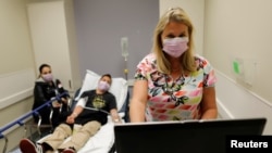 FILE - Emergency room nurse Christine Bauer treats Joshua Lagade of Vista, California, for the flu in the emergency room at Palomar Medical Center in Escondido, California, U.S., Jan.18, 2018. 