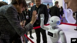A XR-1 5G cloud robot by CloudMinds shakes hands with a visitor at the Mobile World Congress wireless show, in Barcelona, Feb. 25, 2019. CloudMinds has been added to a U.S. "entity list" that bars it from access to U.S. technology without approval. 