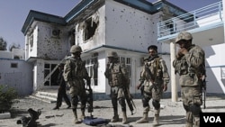 Polisi Afghanistan menunjukkan senjata-senjata yang mereka sita dari pihak militan setelah serangan bom bunuh diri, diikuti dengan pertikaian bersenjata antara kelompok militan dan pasukan AS-Afghanistan di gedung UNHCR di Kandahar.