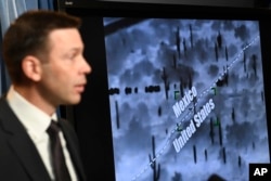 With surveillance footage in the background, U.S. Customs and Border Patrol Commissioner Kevin McAleenan speaks during a news conference in Washington, March 5, 2019.