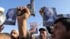 (FILE) Protesters, mainly Houthi supporters, hold posters showing the late Hamas leader Yahya Sinwar as they rally to show support to Lebanon's Hezbollah and Palestinians in the Gaza Strip, in Sanaa, Yemen, Oct. 18, 2024. 