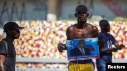 A man holds a photograph of Supreme Court Judge Joseph Mecene Jean-Louis during protests against Haiti's President Jovenel Moise, in Port-au-Prince, Haiti, Feb. 8, 2021. 