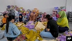 Workers inspect clothing products at Asnur Konveksi, a garment manufacturer in Bandung, West Java province, Indonesia, on July 11, 2024.