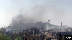 A picture taken with a smart phone shows smoke rising in the village of al-Hosn in the Homs region, about 200 kilometers northwest of Damascus, Syria, March 20, 2014. 