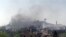 A picture taken with a smart phone shows smoke rising in the village of al-Hosn in the Homs region, about 200 kilometers northwest of Damascus, Syria, March 20, 2014.