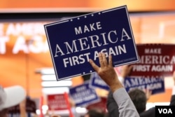 Delegates hold "Make America First Again" posters on the Republican National Convention floor in Cleveland, Ohio, July 20, 2016. (Photo: Ali Shaker/VOA)