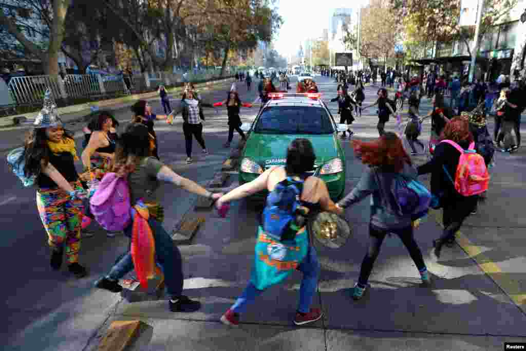 Demonstrators surround a police vehicle during a march demanding an end to sexism and gender violence in Santiago, Chile, June 6, 2018.