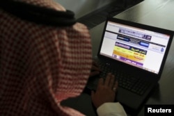 FILE - A Saudi man explores a website on his laptop in Riyadh, Feb. 11, 2014.