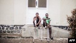 A patient with a leg injury, left, sits next to a patient from Pinga, in Masisi territory, shot in the foot, at the ICRC hospital, in Goma, on Jan. 20, 2025.