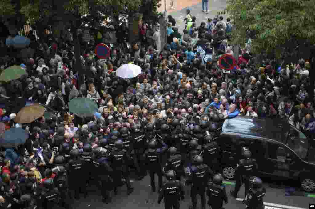 La Policía Nacional impide que las personas ingresen a una escuela asignada a una mesa de votación por parte del gobierno catalán en Barcelona, ​​el 1 de octubre de 2017.