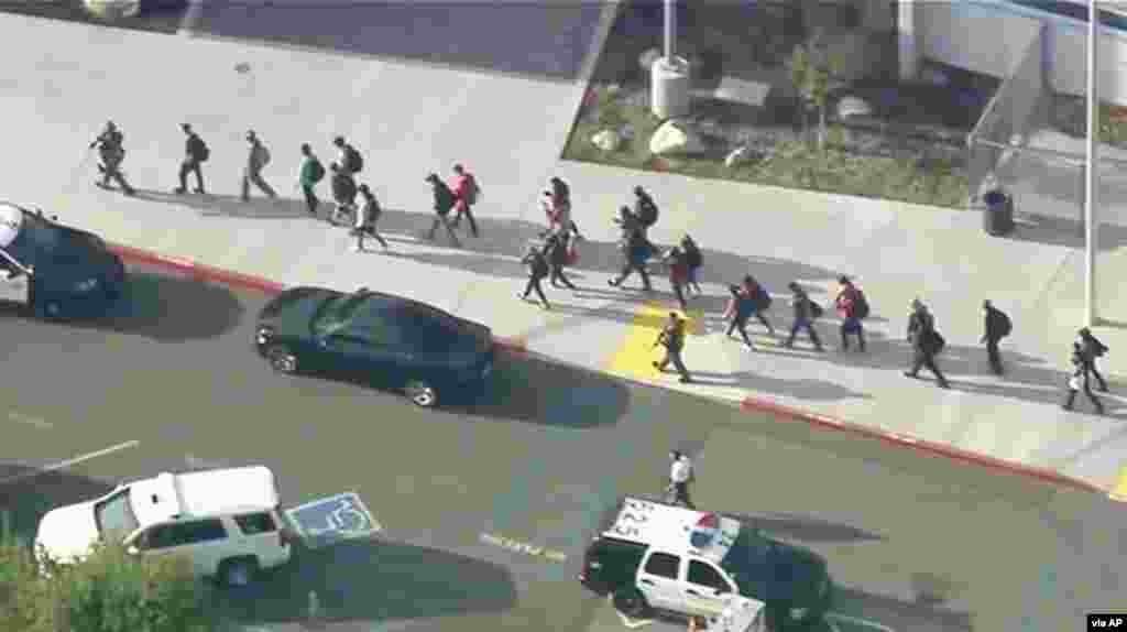 Students are lead out of Saugus High School after reports of a shooting in Santa Clarita, California. Authorities said a student gunman opened fire at the school, leaving one person dead and several others injured. (Credit: KTTV-TV)