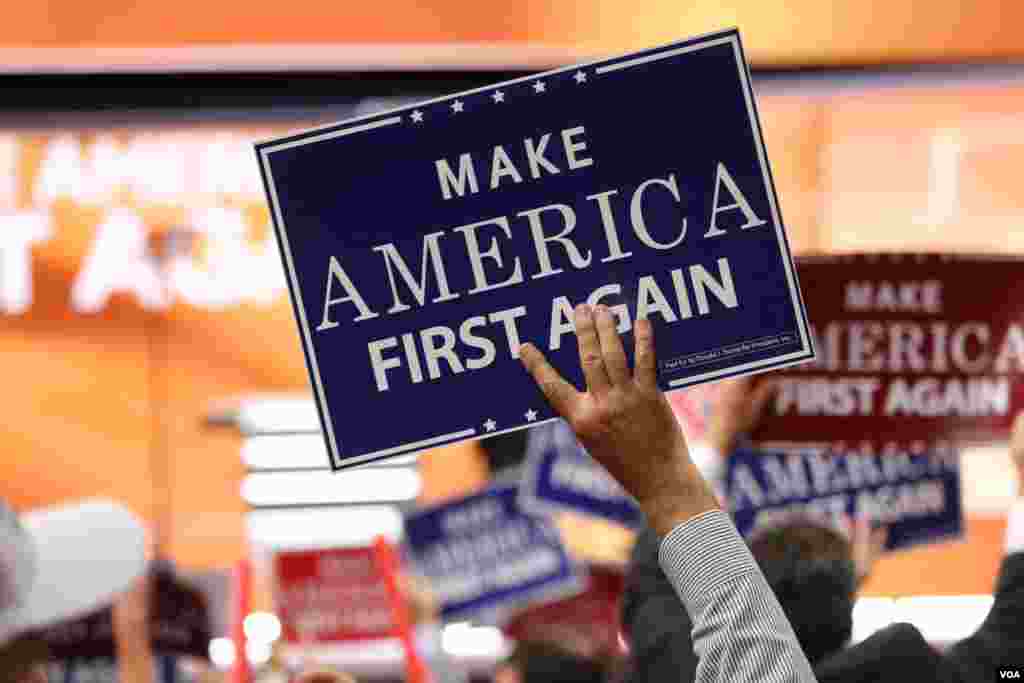 Delegates hold &quot;Make America First Again&quot; posters on the Republican National Convention floor in Cleveland, Ohio, July 20, 2016. (Photo: A. Shaker / VOA)